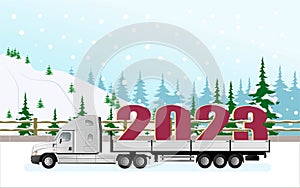 A modern American truck with a semi-trailer carries the symbol of the new year 2023 in the snowfall