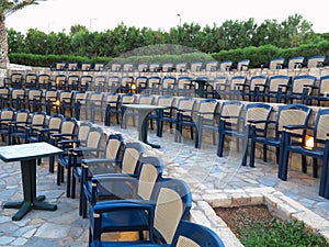 Modern amphitheater plastic chairs and palm trees in Greece