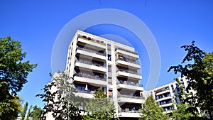 Modern apartment building and green trees. Ecological housing architecture.