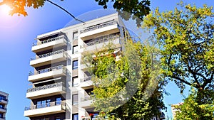 Modern apartment building and green trees. Ecological housing architecture.