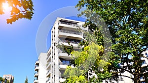 Modern apartment building and green trees. Ecological housing architecture.