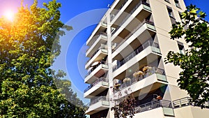 Modern apartment building and green trees. Ecological housing architecture.