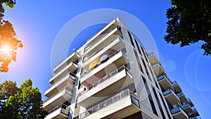 Modern apartment building and green trees. Ecological housing architecture.