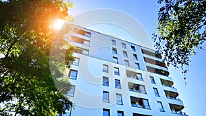 Modern apartment building and green trees. Ecological housing architecture.