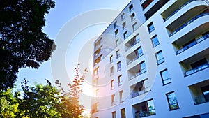 Modern apartment building and green trees. Ecological housing architecture.