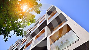 Modern apartment building and green trees. Ecological housing architecture.