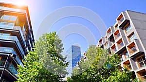 Modern apartment building and green trees. Ecological housing architecture.