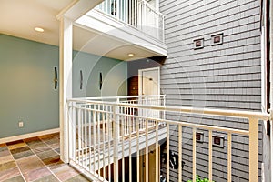 Modern apartment building hallway and door near railing.