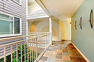 Modern apartment building hallway and door near railing.