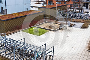 Modern apartment building\'s courtyard, complete with a children\'s playground and designated bicycle parking.