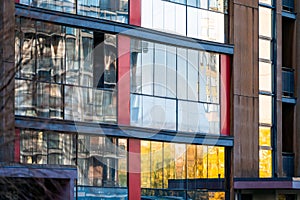 Modern apartment building wall with large windows close-up, reflections in the glass