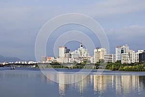 Modern apartment buildings mirrored in a canal, Sanya, China