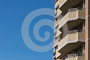 Modern apartment, hotel building on blue sky background from worm eyes view