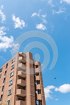 Modern apartment, hotel building on blue sky background from worm eyes view