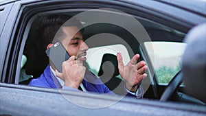 Modern arab man in formal wear sitting in right-hand drive car