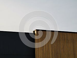 Modern architectural details, wooden wall and black metal wall against sky