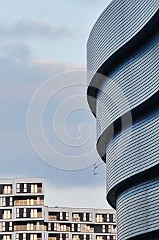 Modern architectural shapes, modern building facade, glass, metal, a large number of windows, curves on the buildings