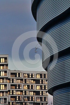 Modern architectural shapes, modern building facade, glass, metal, a large number of windows, curves on the buildings