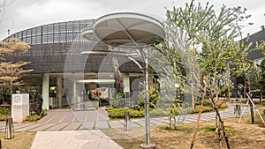 Modern architectural structure with garden path and cloudy sky.