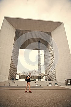 Modern architecture. Backpacker exploring city. Summer vacation. Woman stand in front of urban architecture. Must visit