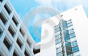 Modern architecture building with blue cloudy sky, abstract low angle clouds exterior office skyscaper background