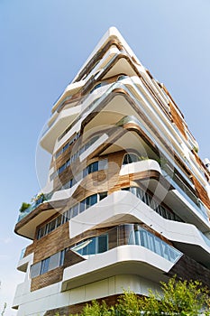 Modern architecture building in Milan, Italy. White and wooden materials used in construction.