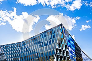 Modern architecture building with mirrors. Sky with clouds on th