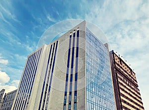 Modern architecture, glass facade with windows of residential or commercial, office building on a sunny day