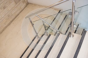 Modern architecture with marble stairs.marble staircase with glass handrails. White steps leading down.modern interior