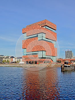 Modern architecture of the MAS museum, refleecting in the water of a dock Antwerp