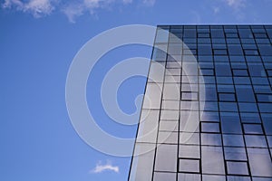 Modern architecture of office buildings. A skyscraper from glass and metal. Reflections in windows of blue sky. Business center