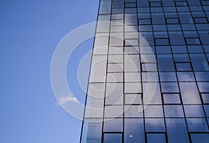 Modern architecture of office buildings. A skyscraper from glass and metal. Reflections in windows of blue sky. Business center