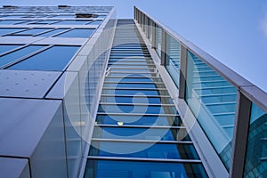 Modern architecture of office buildings. A skyscraper from glass and metal. Reflections in windows of blue sky. Business center