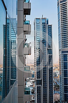 Modern architecture of a skyscraper with a large number of balconies against the background of the blue sky and the city