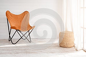 Modern armchair in modern loft interior. Sunny day in light living room with panoramic windows.