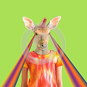 Modern art collage. The figure of a girl with a deer head with a unicorn horn on a green background with rays from the eyes.