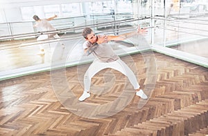 Modern art dancer teenager practices a dance movements in mirror hall