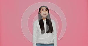 Modern asian young girl chew bubblegum, blow bubble on pink background with copyspace for ad. Dental health and hygiene