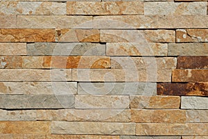 Modern authentic beige, brown and gray stone masonry wall texture background. Rustic architecture building facade, house