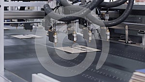 Modern automatic machine line of cardboard box. Offset printing machine - spraying glue. Conveyor line for the