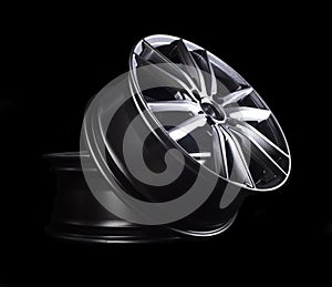 Modern automotive alloy wheel made of aluminum on a black background, industry. Designer fashion wheels for car