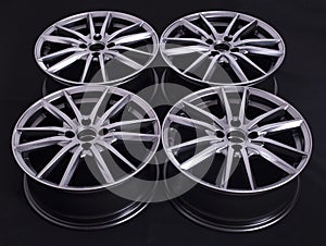 Modern automotive alloy wheel made of aluminum on a black background, industry. Designer fashion wheels for car