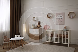 Modern baby room interior with stylish furniture and toys