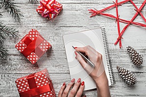 A modern background of a white background carnet background, and a young lady who writes a Christmas message with a white message.