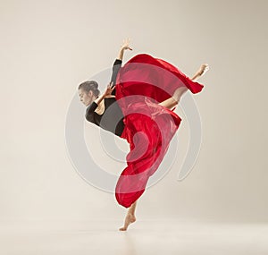 Modern ballet dancer dancing in full body on white studio background.