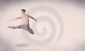 Modern ballet dancer performing art jump with empty background