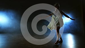 Modern ballet dancing woman barefoot lying on the floor doing spins and pirouettes and somersaults