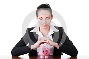 Modern bank model. Business woman sitting with piggy-bank.