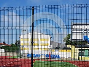 Modern basketball court in the courtyard of primary school. Multifunctional children`s playground with artificial surfaced fenced