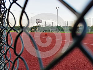 Modern basketball court in the courtyard of primary school. Multifunctional children`s playground with artificial surfaced fenced